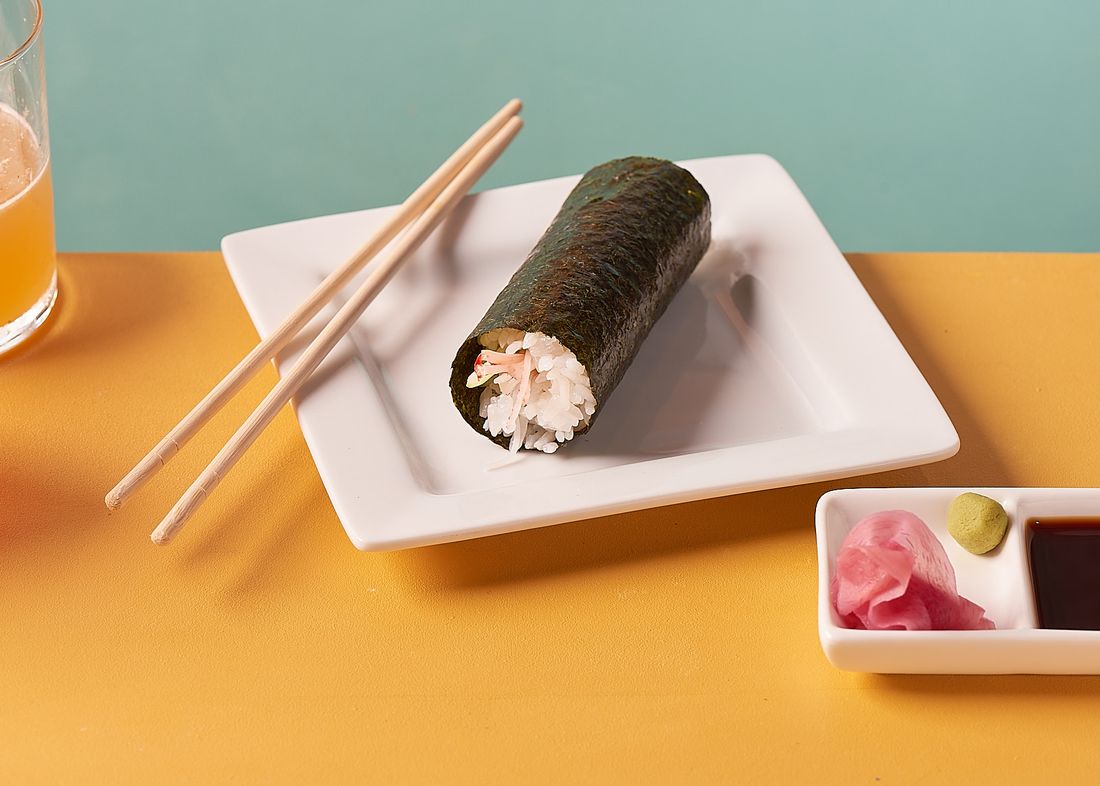 A crab hand roll on a white plate